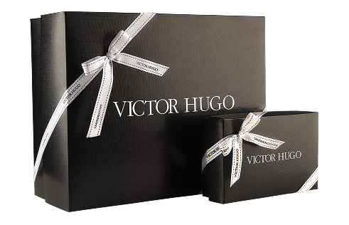 Duas caixas de presente Victor Hugo em preto, fechadas com laço de fita personalizada com a assinatura VH